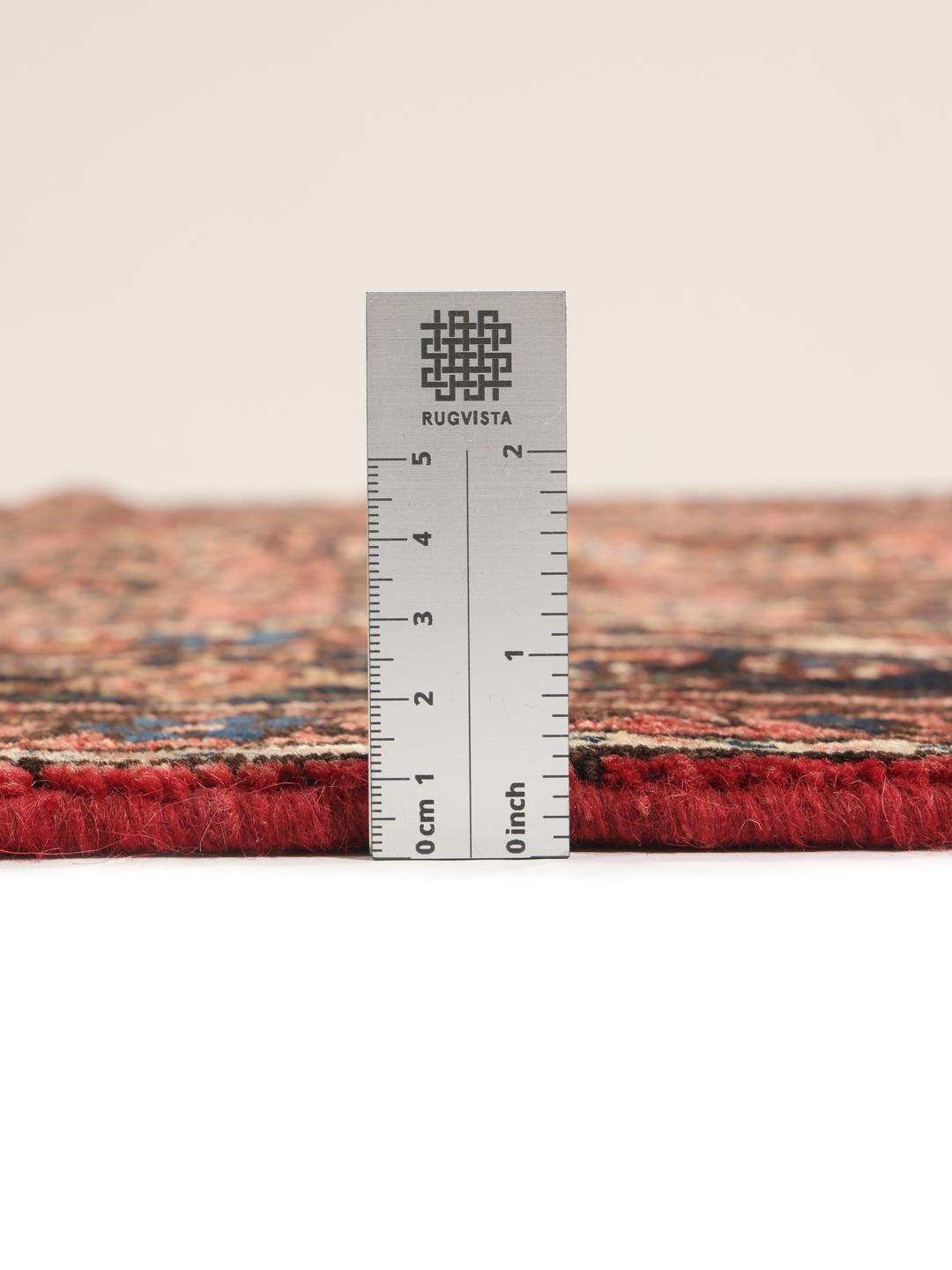 A hand-knotted Hosseinabad rug from the Middle East featuring a dark-red field and intricate patterns.