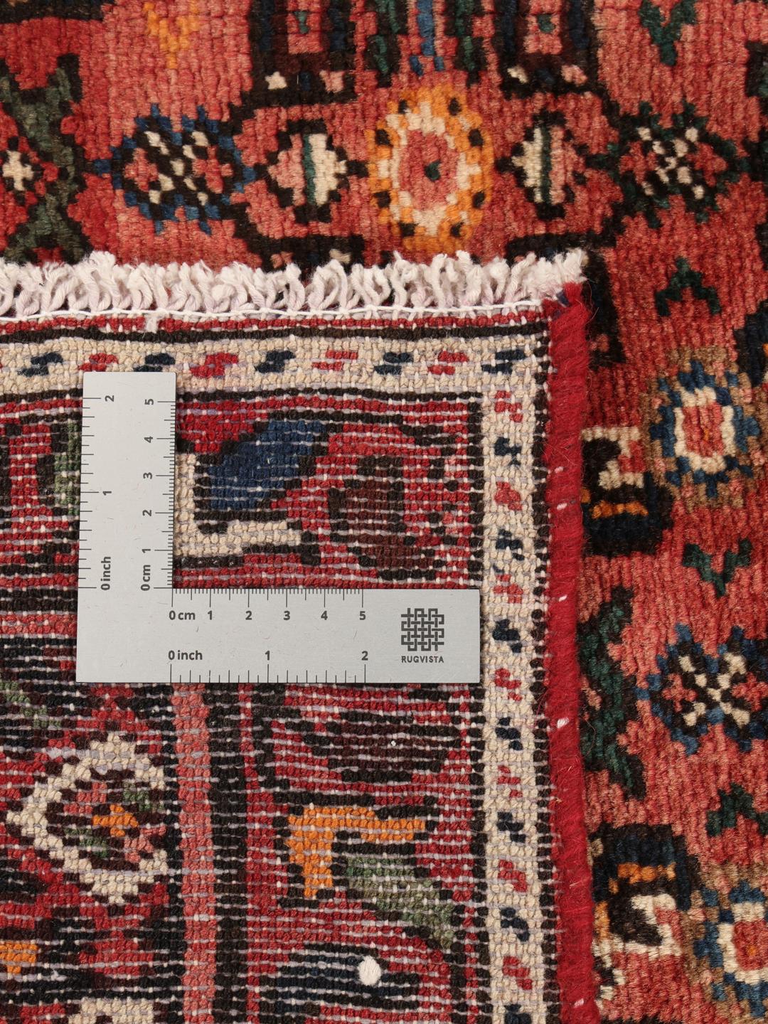 A hand-knotted Hosseinabad rug from the Middle East featuring a dark-red field and intricate patterns.