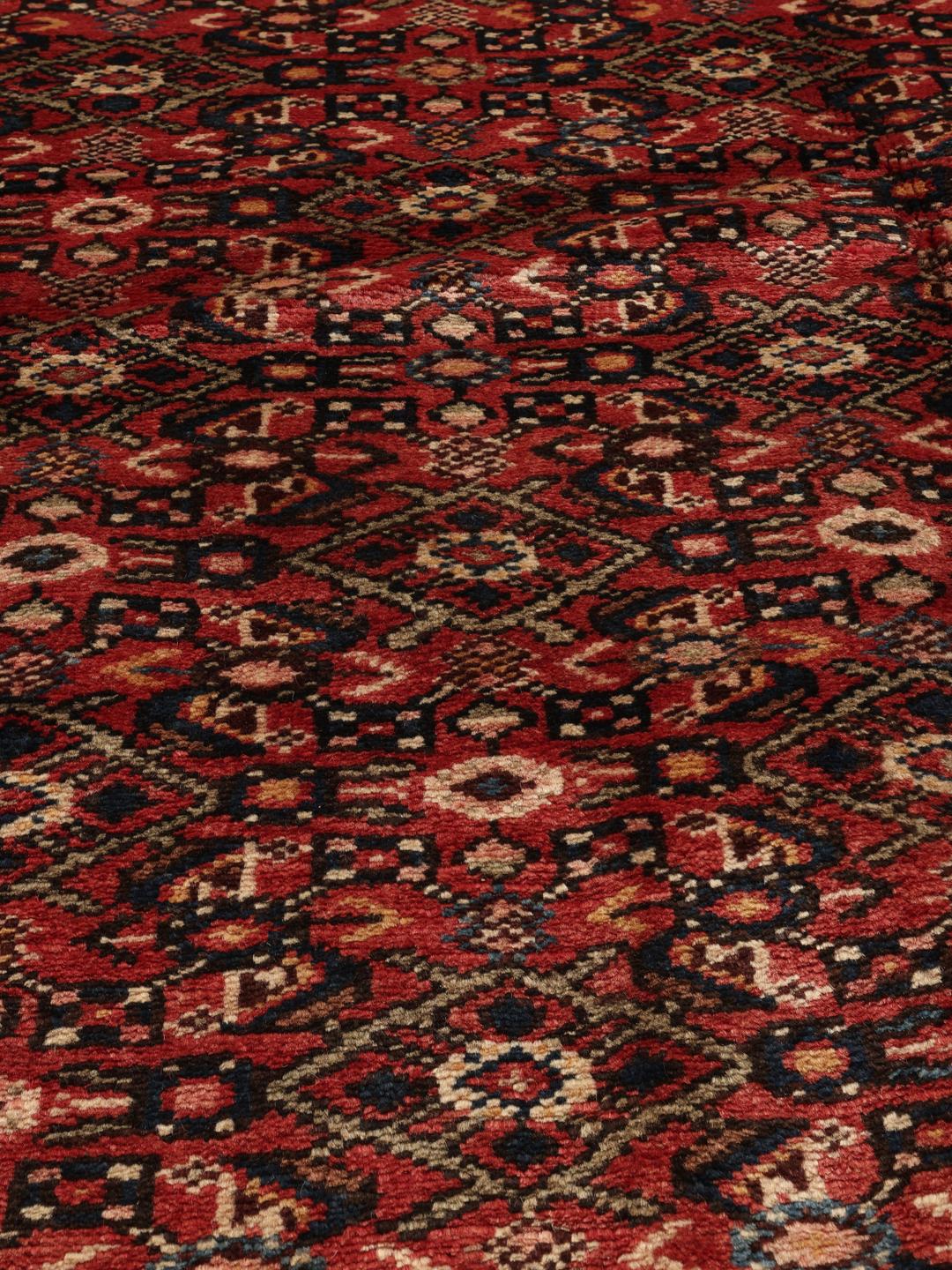 Hand-knotted Hosseinabad rug from the Middle East in deep red and black