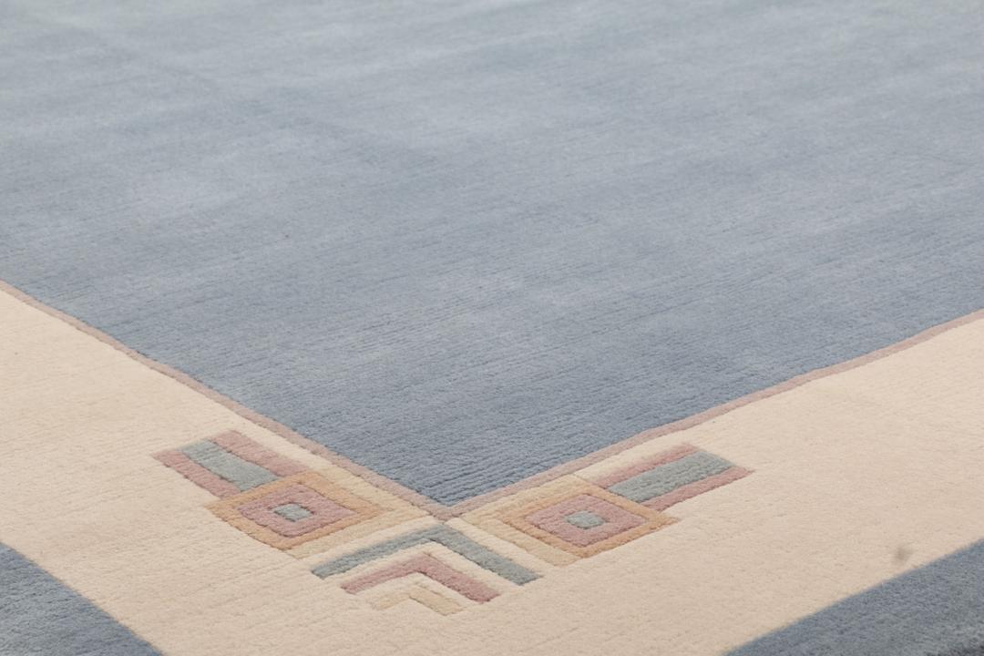 Handgeknoopt blauw wollen tapijt uit Nepal met een minimalistisch randontwerp