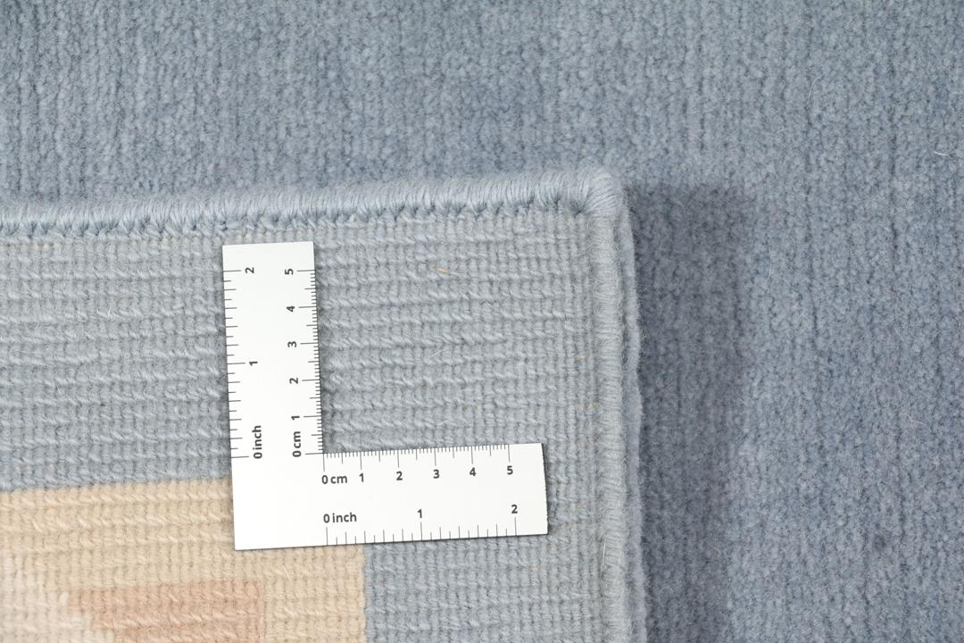 Handgeknoopt blauw wollen tapijt uit Nepal met een minimalistisch randontwerp