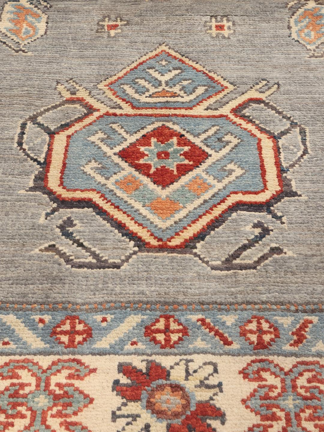 Handgeknoopt Kazak-tapijt uit Afghanistan met een grijs veld en traditionele geometrische motieven.