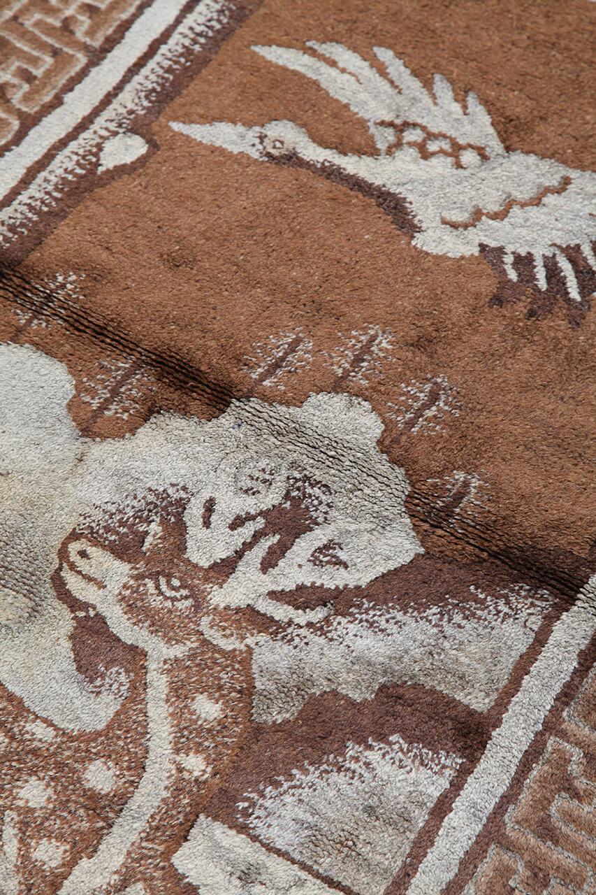 Antikt kinesisk tæppe med hjorte- og fuglemotiver i brune og beige nuancer