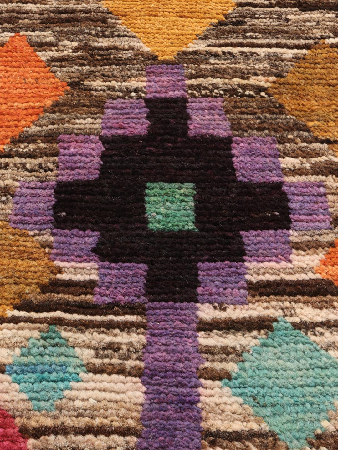 Handgeknoopt Afghaans tapijt met een veelkleurig geometrisch patroon op een bruine basis.