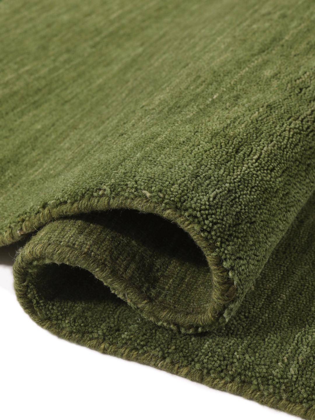 Um tapete de pelo verde com franjas curtas a condizer