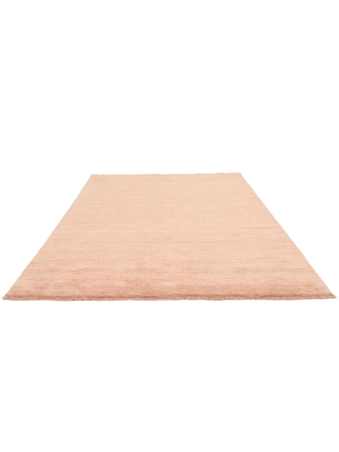 Een eenkleurig roze handgeweven poolvloerkleed met korte franjes