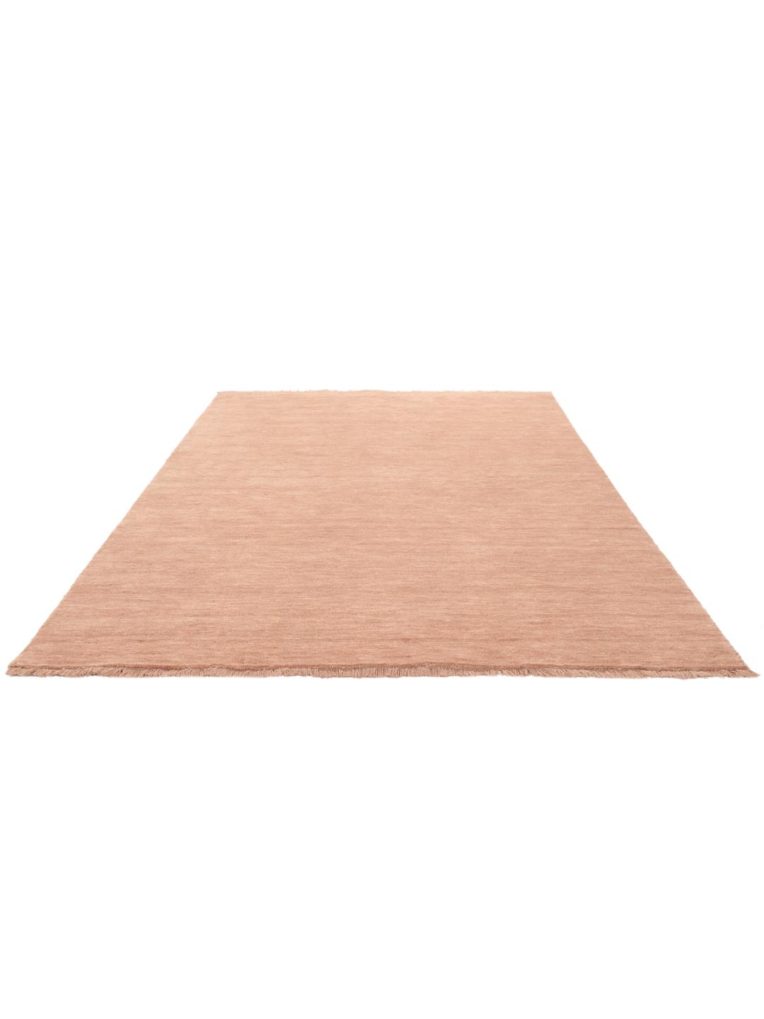 Een eenkleurig roze handgeweven poolvloerkleed met korte franjes
