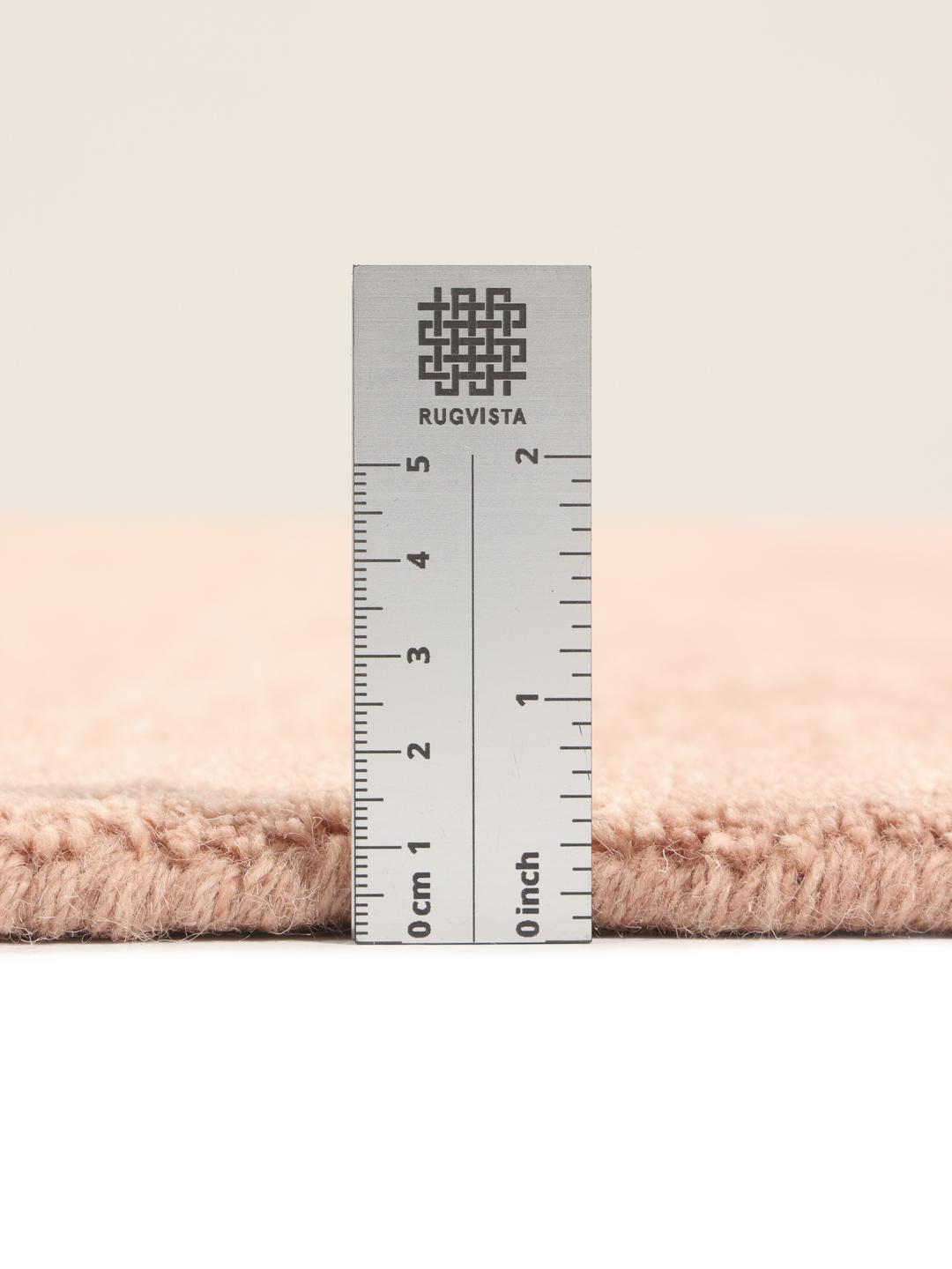 Een eenkleurig roze handgeweven poolvloerkleed met korte franjes