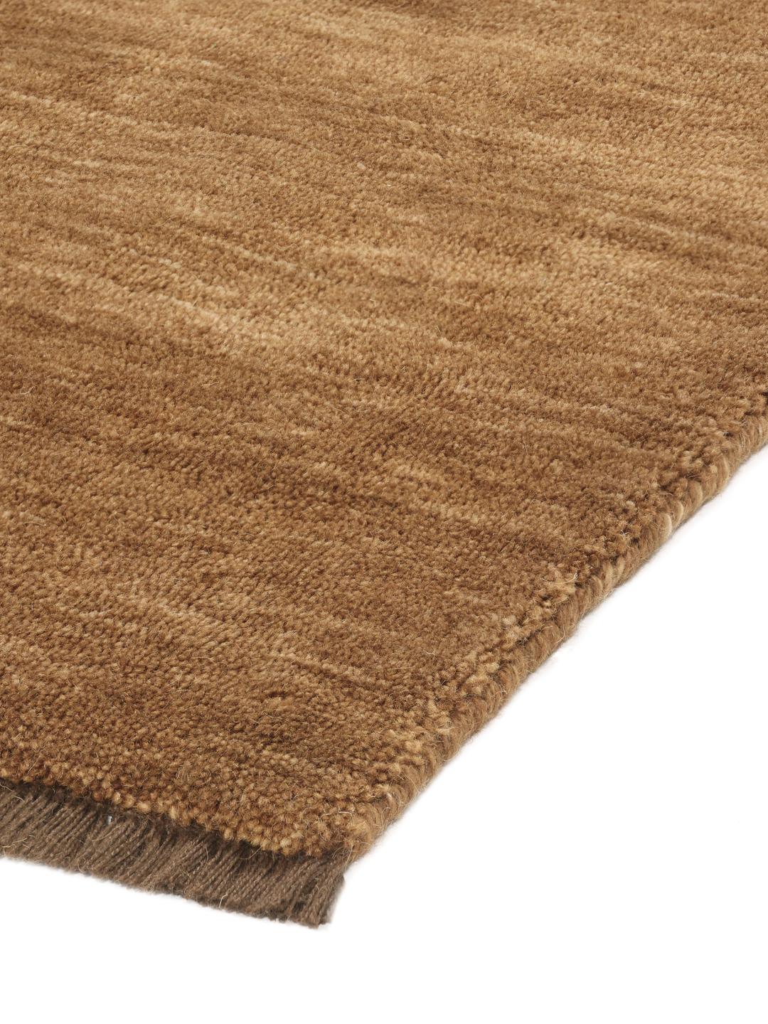 Un tapis à poils ras de couleur brune unie avec des franges courtes