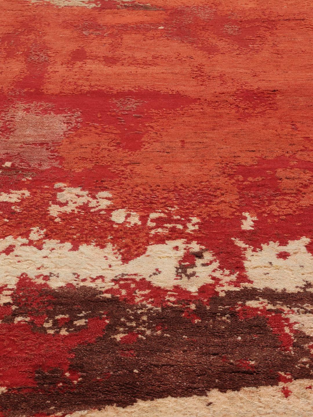 Een modern, levendig rood handgeknoopt tapijt uit India met artistieke, abstracte patronen.