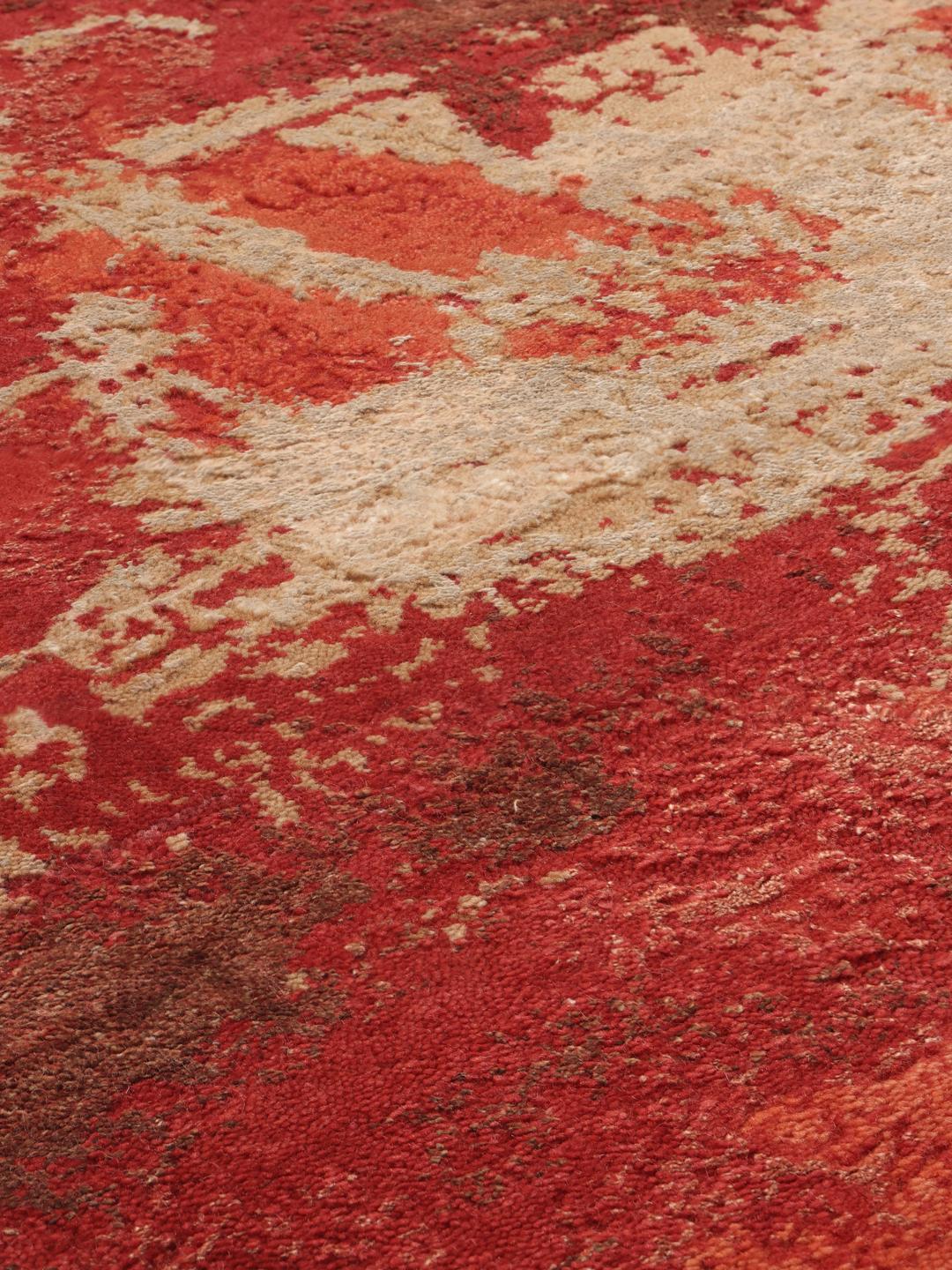 Een modern, levendig rood handgeknoopt tapijt uit India met artistieke, abstracte patronen.