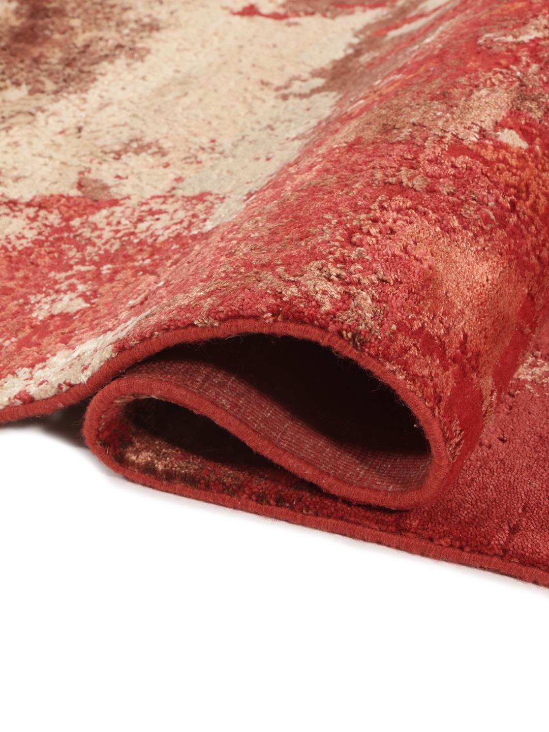 Een modern, levendig rood handgeknoopt tapijt uit India met artistieke, abstracte patronen.