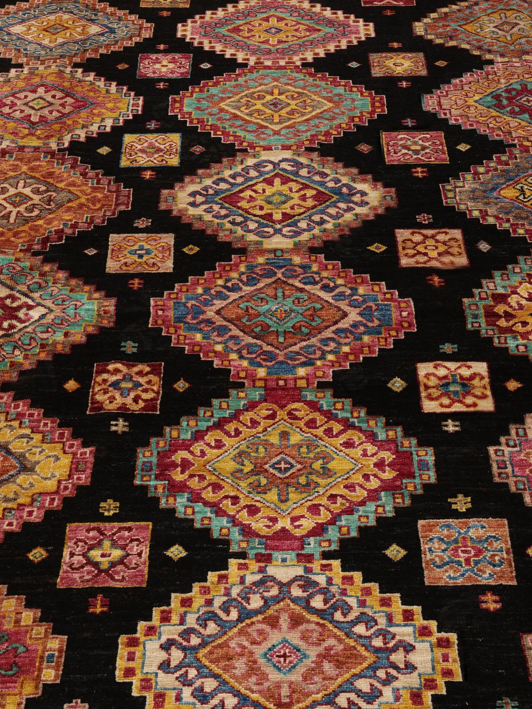 Hand-knotted Afghan rug with a black field and multicoloured diamond patterns.