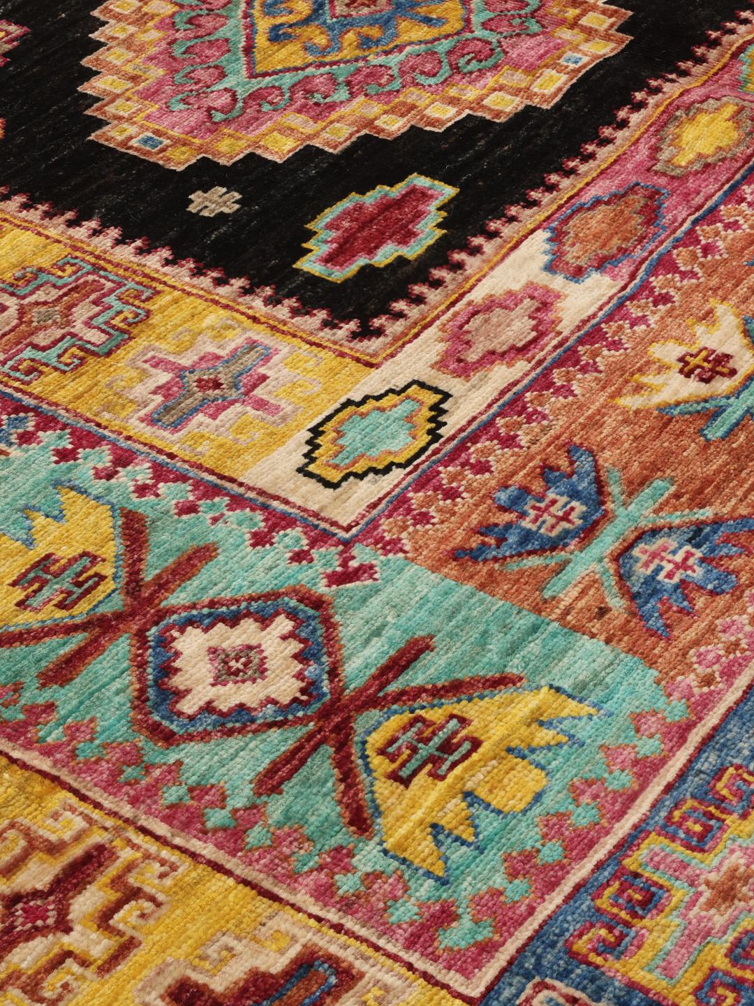 Hand-knotted Afghan rug with a black field and multicoloured diamond patterns.