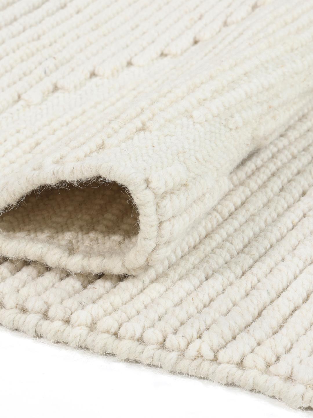 Een handgeweven wit tapijt van Wool met een subtiel chevronpatroon en franjes.