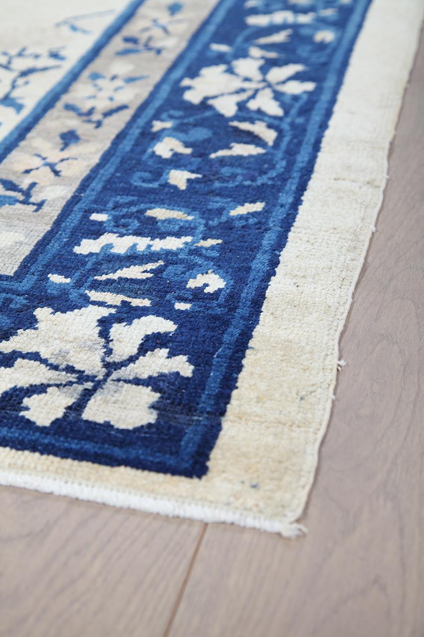 Antikt kinesisk tæppe med blomstermotiver og central medaljon i beige og blå