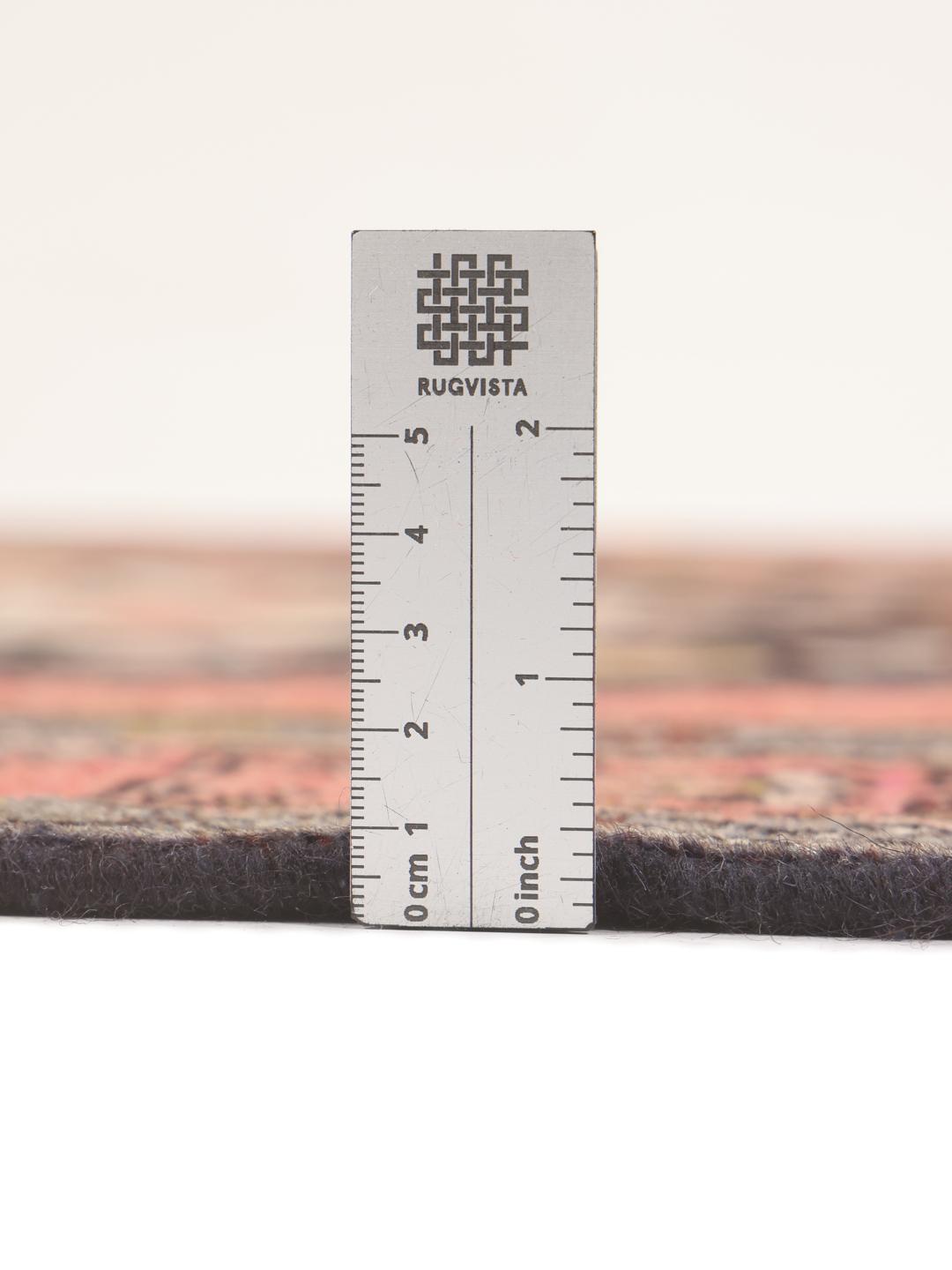 Et håndknyttet mellemøstligt Hamadan-tæppe med et sort og rødt geometrisk medaljondesign.