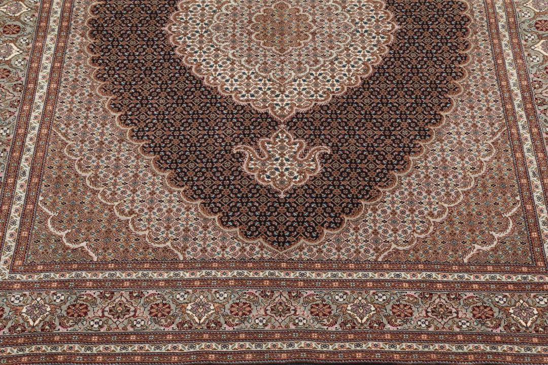 Et håndknyttet Tabriz 50 Raj-tæppe fra Mellemøsten med et medaljondesign i flere farver.