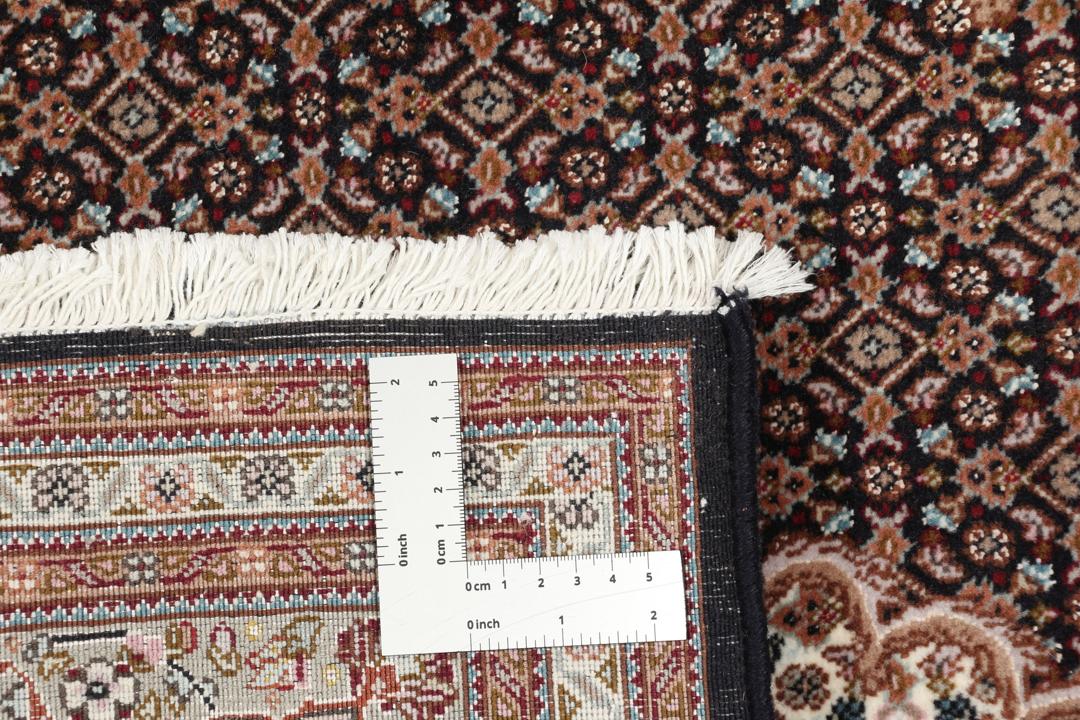 Et håndknyttet Tabriz 50 Raj-tæppe fra Mellemøsten med et medaljondesign i flere farver.