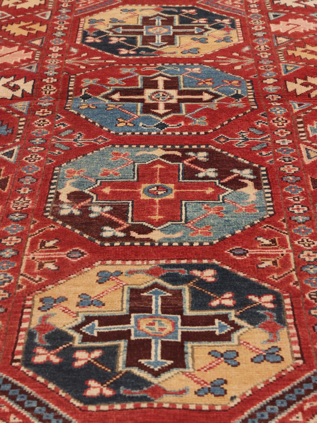 Pasarelă Kazak înnodată manual din Afganistan cu motive geometrice roșii, albastre și galbene.