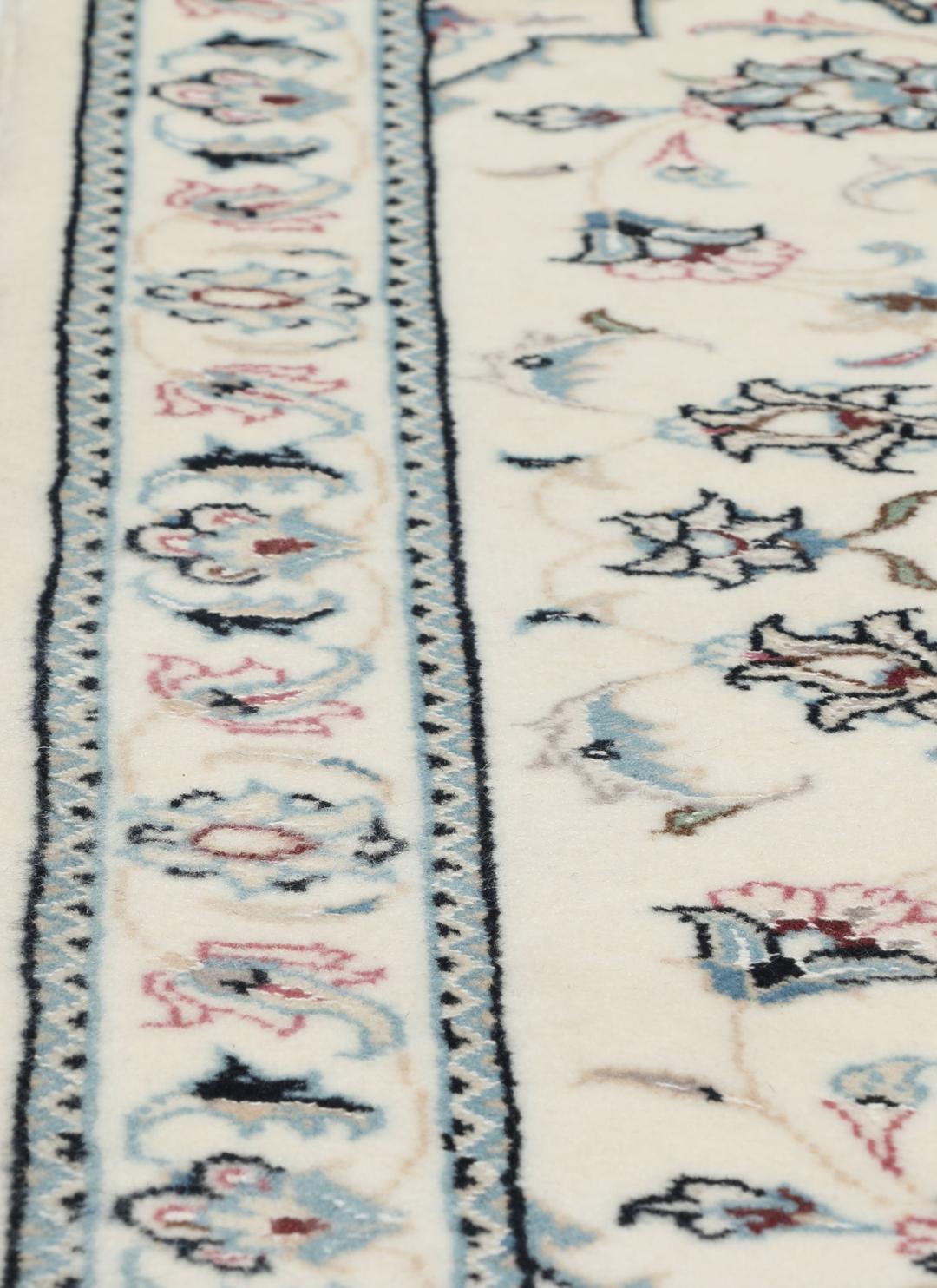 A hand-knotted Nain 9La rug from the Middle East in beige, blue, and pink colours.