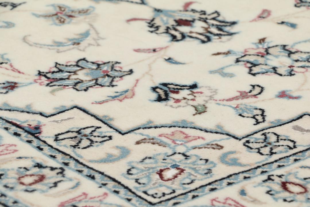 A hand-knotted Nain 9La rug from the Middle East in beige, blue, and pink colours.