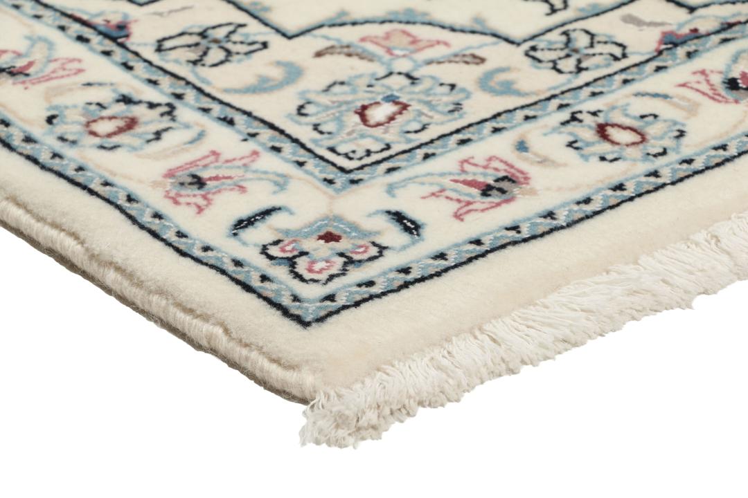 A hand-knotted Nain 9La rug from the Middle East in beige, blue, and pink colours.