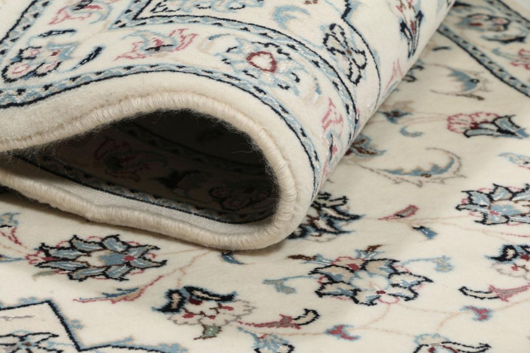 A hand-knotted Nain 9La rug from the Middle East in beige, blue, and pink colours.