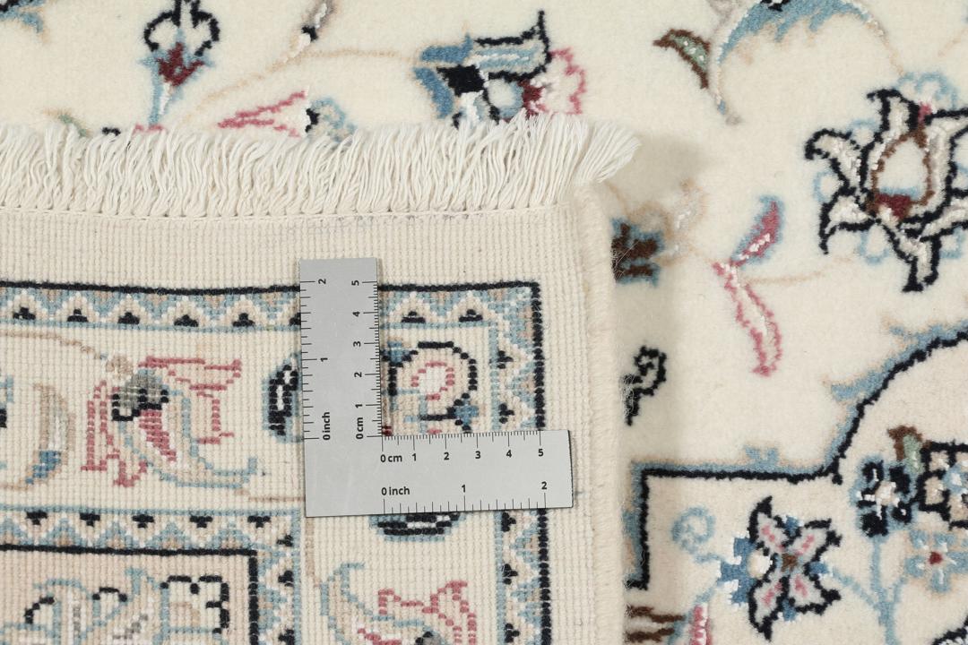 A hand-knotted Nain 9La rug from the Middle East in beige, blue, and pink colours.