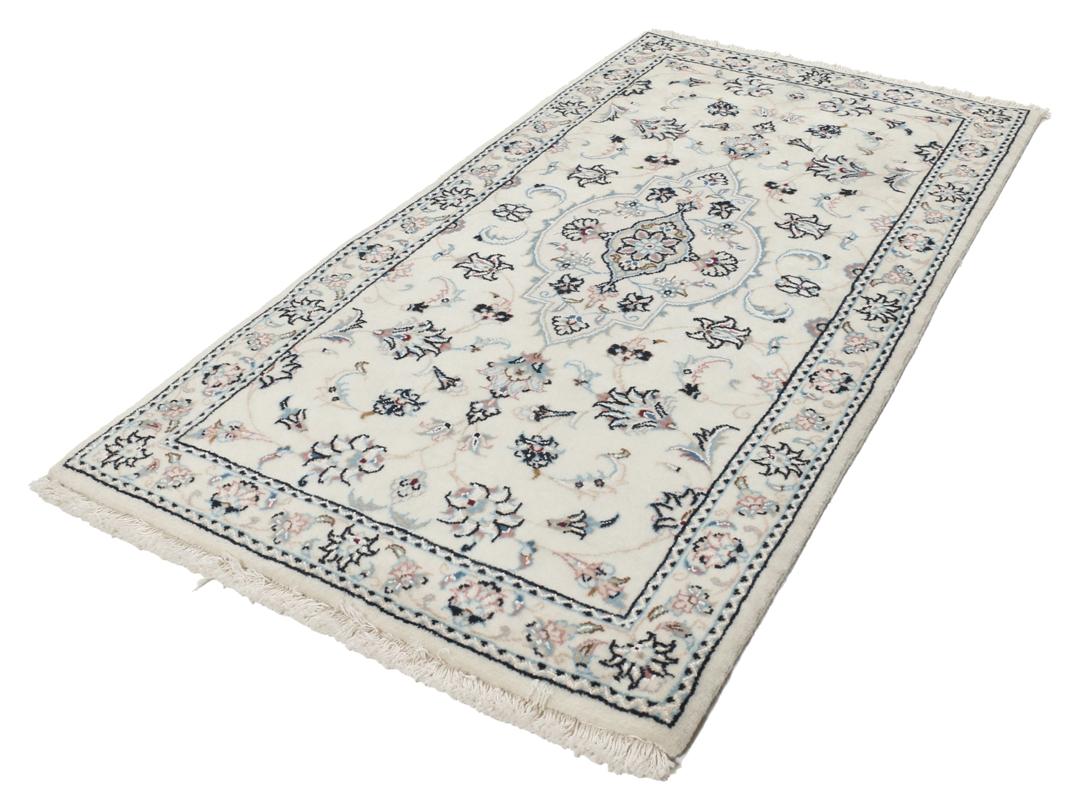 Een handgeknoopt Nain 9La-tapijt uit het Midden-Oosten met een beige achtergrond en bloemmotieven.