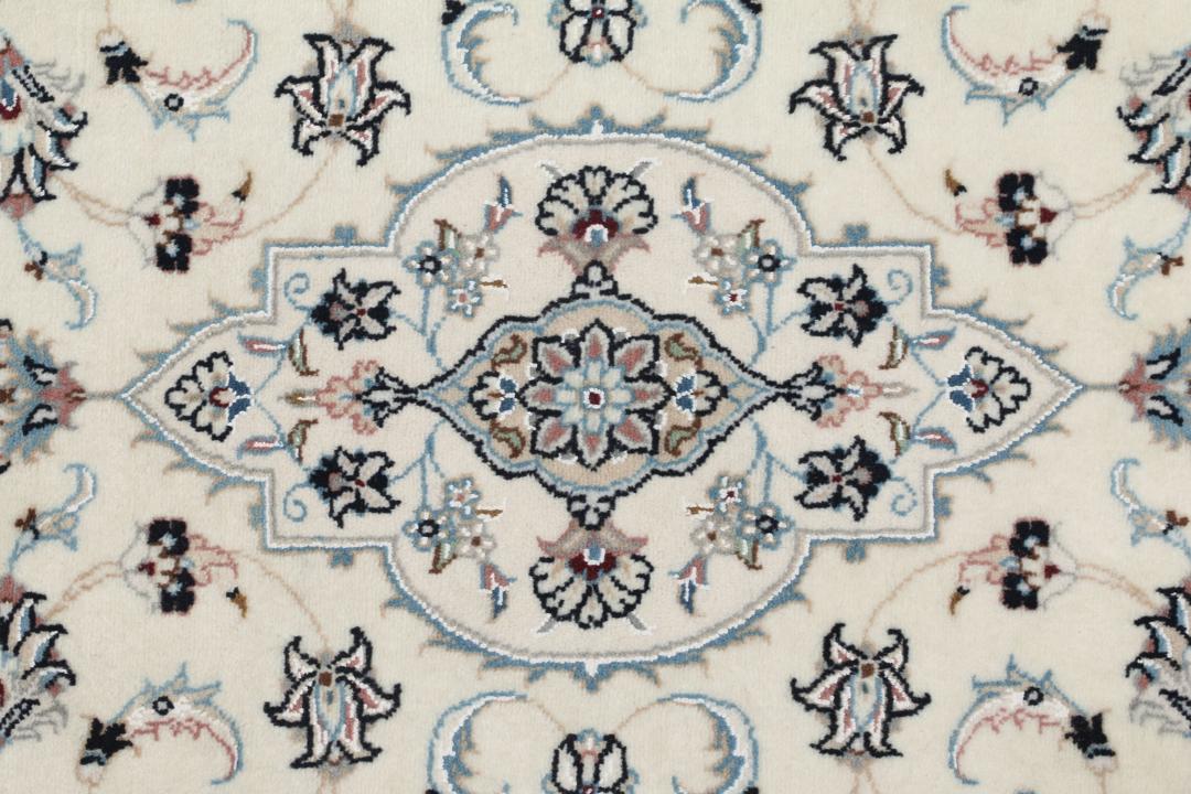 Een handgeknoopt Nain 9La-tapijt uit het Midden-Oosten met een beige achtergrond en bloemmotieven.