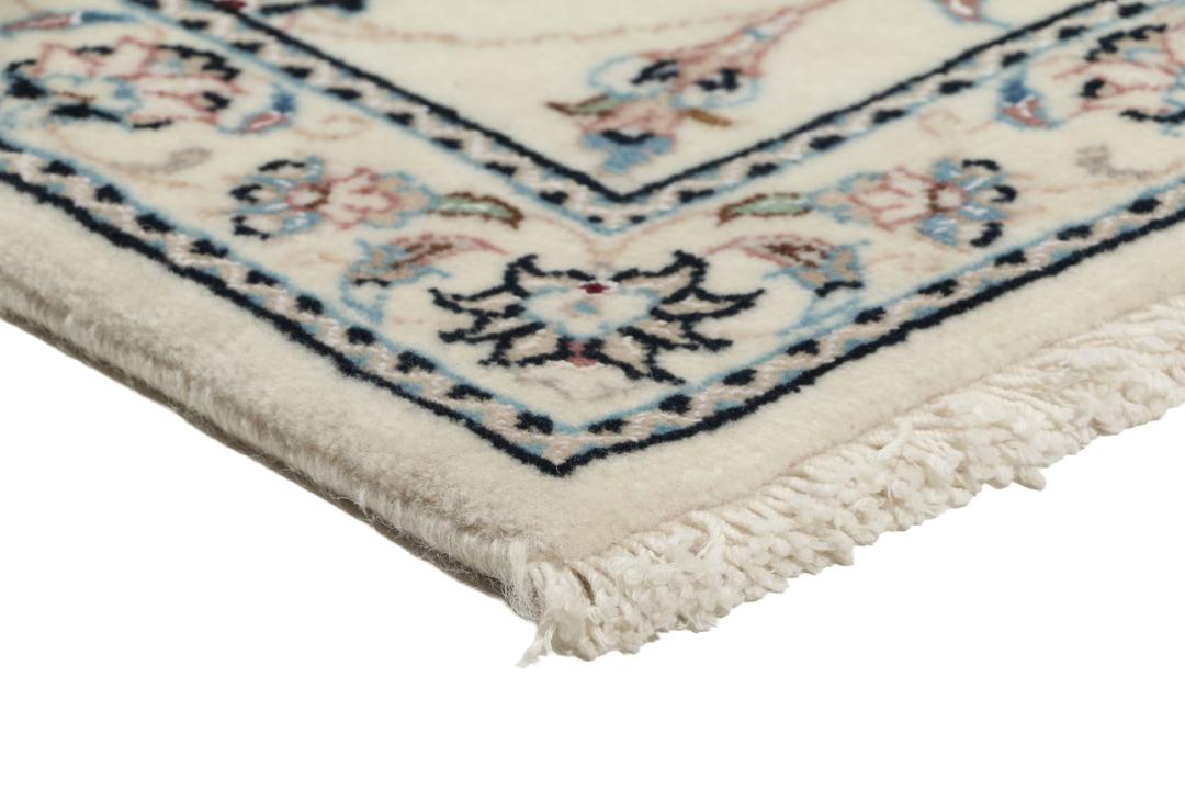 Een handgeknoopt Nain 9La-tapijt uit het Midden-Oosten met een beige achtergrond en bloemmotieven.