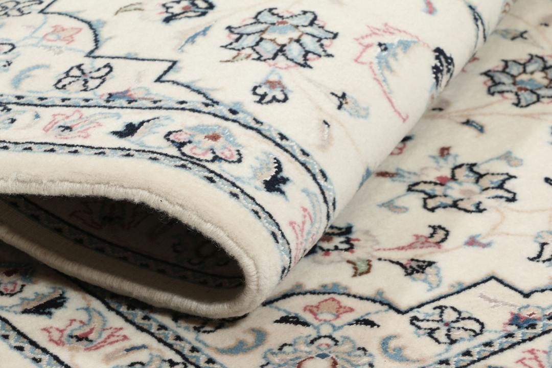 Een handgeknoopt Nain 9La-tapijt uit het Midden-Oosten met een beige achtergrond en bloemmotieven.