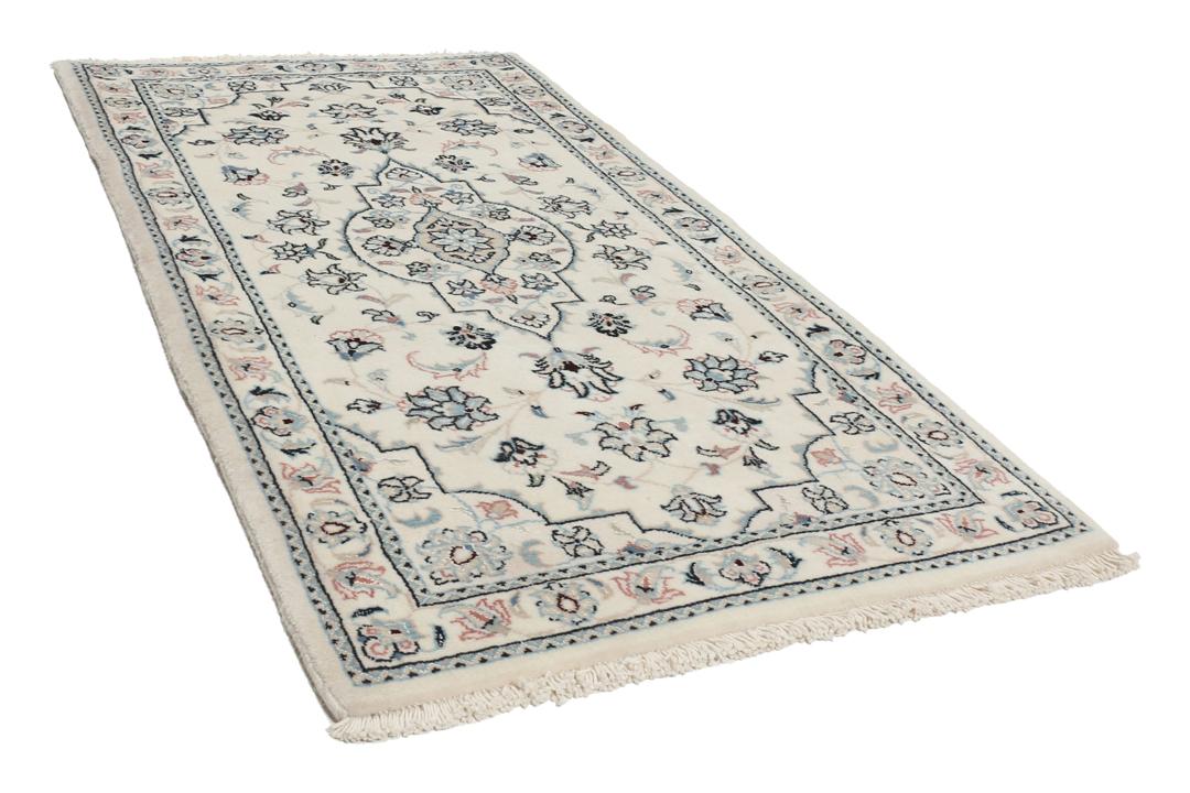 Een handgeknoopt Nain 9La tapijt met delicate bloemmotieven op een beige achtergrond.