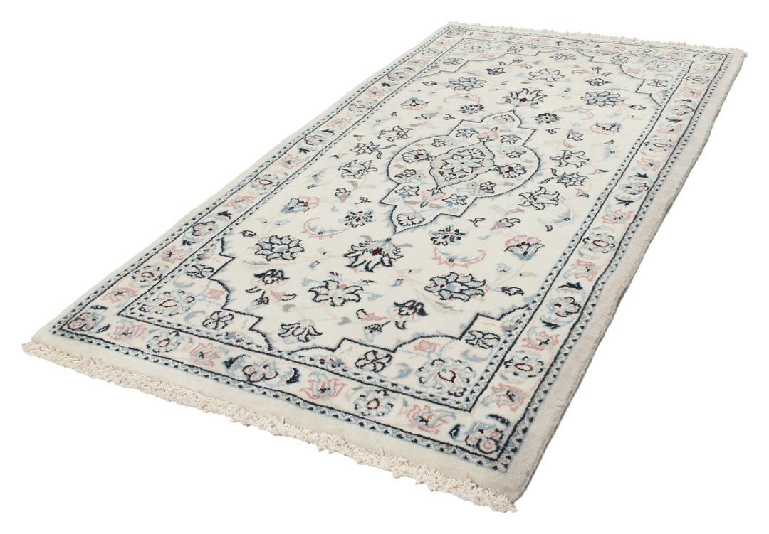 Een handgeknoopt Nain 9La tapijt met delicate bloemmotieven op een beige achtergrond.