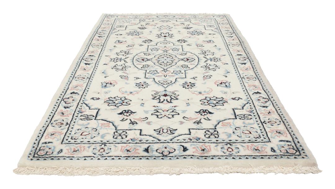Een handgeknoopt Nain 9La tapijt met delicate bloemmotieven op een beige achtergrond.