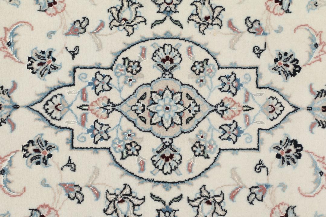 Een handgeknoopt Nain 9La tapijt met delicate bloemmotieven op een beige achtergrond.