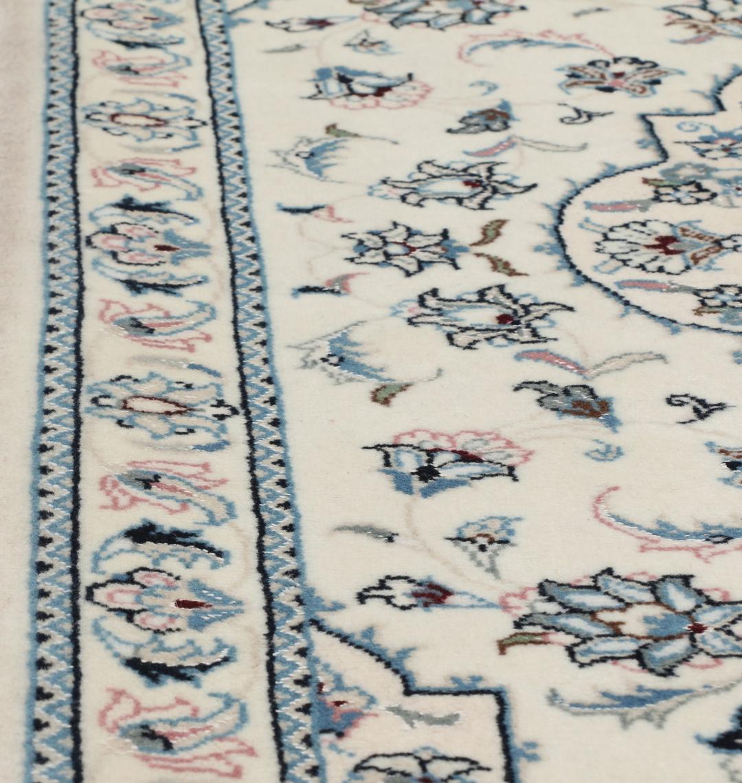 Een handgeknoopt Nain 9La tapijt met delicate bloempatronen in beige en blauw uit het Midden-Oosten