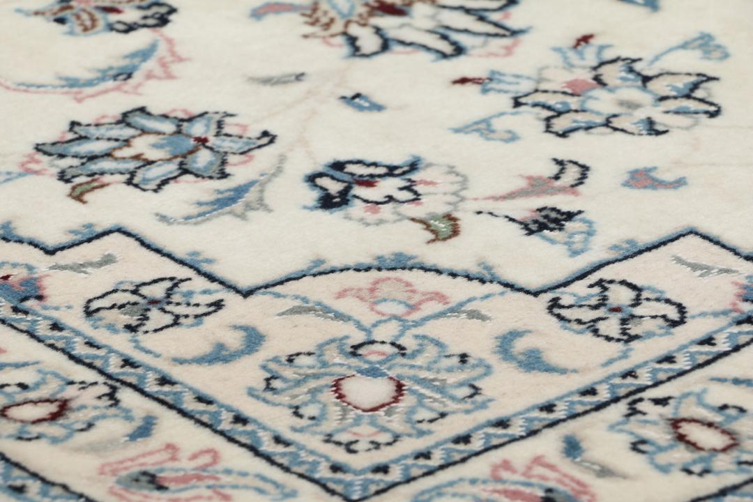 Een handgeknoopt Nain 9La tapijt met delicate bloempatronen in beige en blauw uit het Midden-Oosten