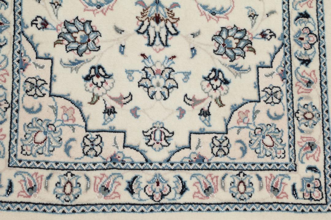 Een handgeknoopt Nain 9La tapijt met delicate bloempatronen in beige en blauw uit het Midden-Oosten