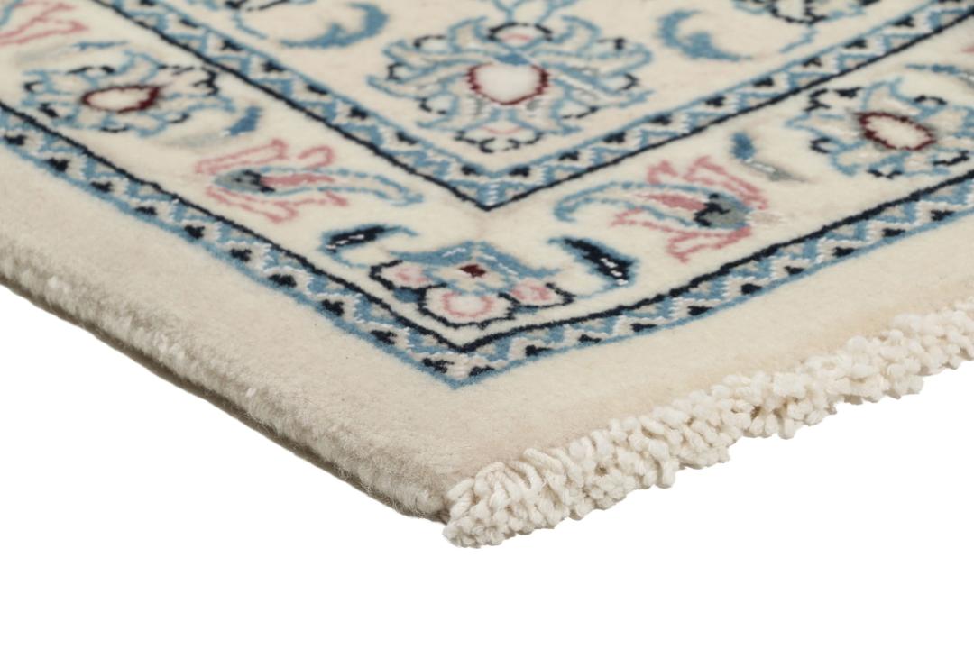 Een handgeknoopt Nain 9La tapijt met delicate bloempatronen in beige en blauw uit het Midden-Oosten