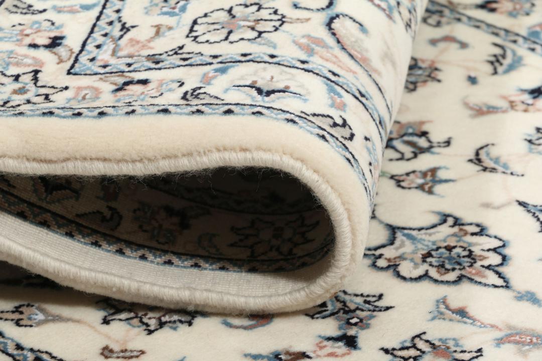 Håndknyttet Nain 9La tæppe fra Mellemøsten med en cremet baggrund og blomstermotiver.