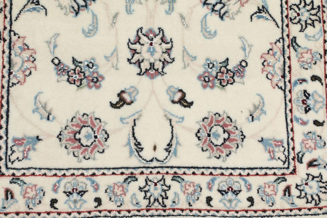 Handgeknoopt Nain 9La tapijt met delicate blauwe en roze bloemmotieven op een beige achtergrond