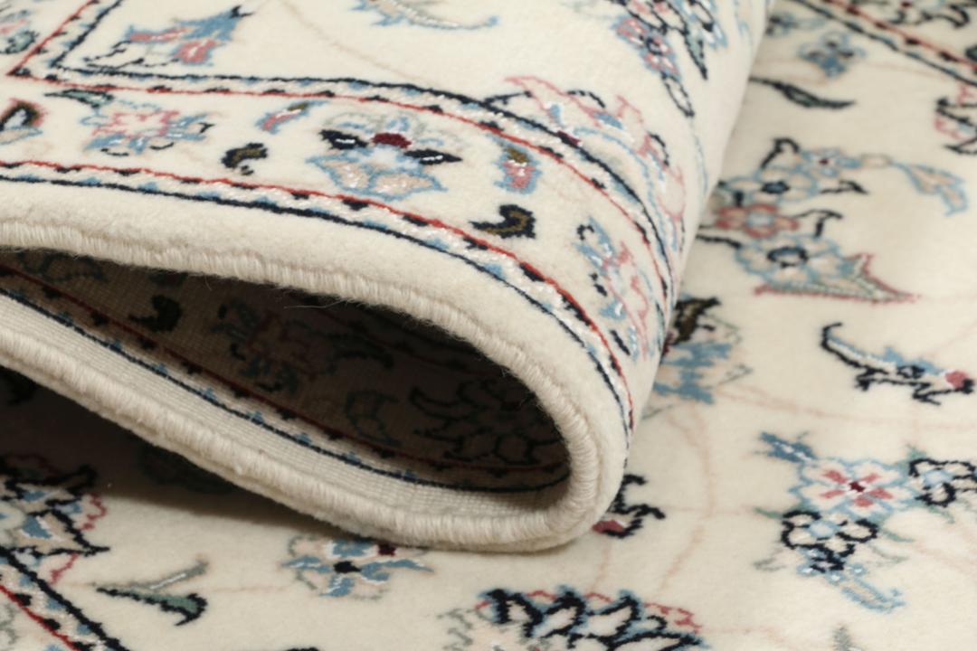 Handgeknoopt Nain 9La tapijt met delicate blauwe en roze bloemmotieven op een beige achtergrond