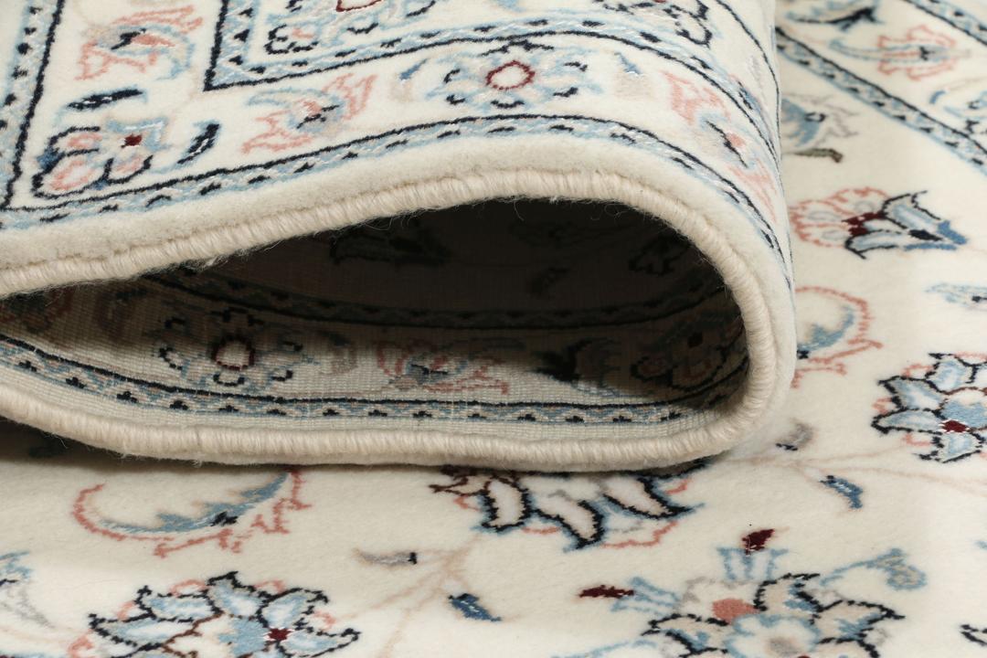 Handgeknoopt Nain 9La tapijt met een bloemmedaillonontwerp in beige, blauwe en roze tinten.
