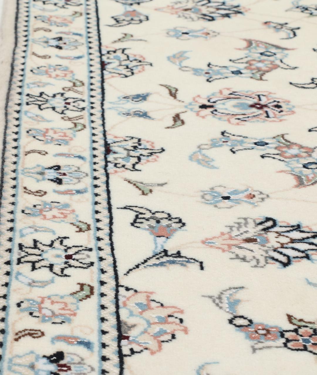 A hand-knotted Nain 9La rug from the Middle East featuring floral patterns in beige and soft blue.