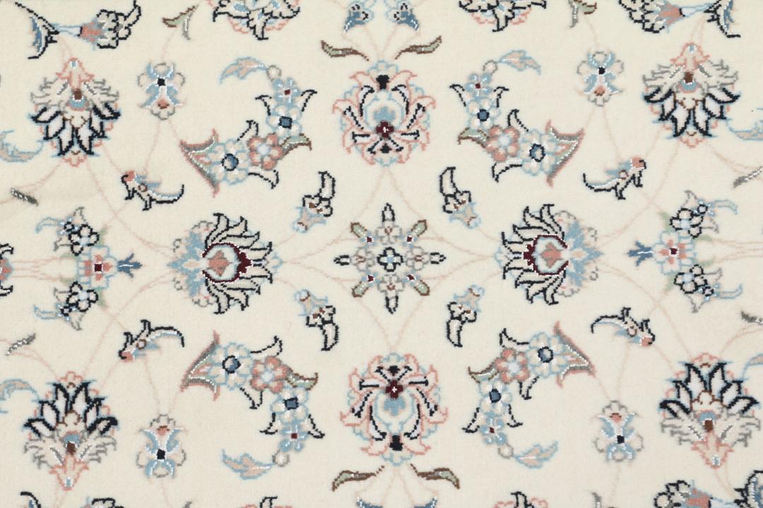 A hand-knotted Nain 9La rug from the Middle East featuring floral patterns in beige and soft blue.