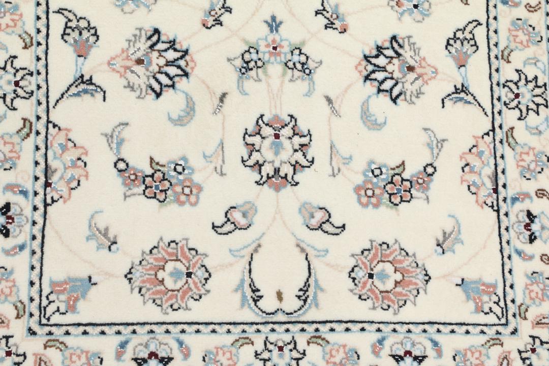 A hand-knotted Nain 9La rug from the Middle East featuring floral patterns in beige and soft blue.
