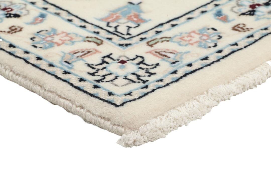 A hand-knotted Nain 9La rug from the Middle East featuring floral patterns in beige and soft blue.