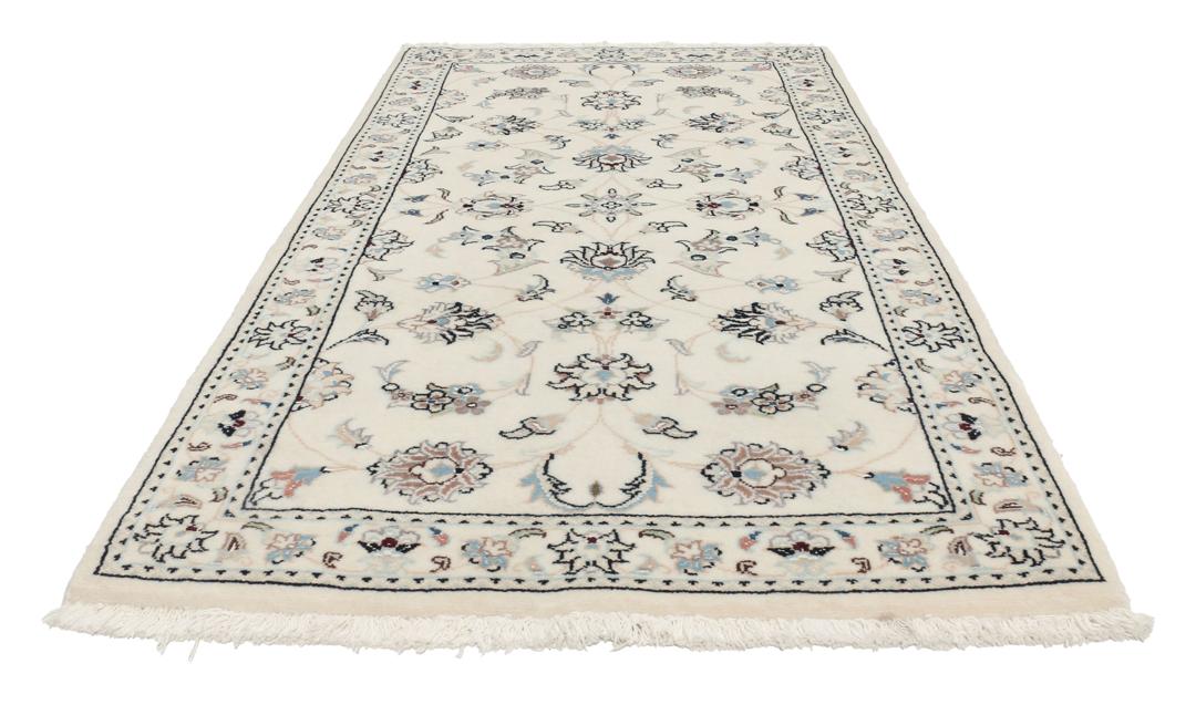 Een rechthoekig handgeknoopt Nain 9La tapijt met een beige veld en florale motieven uit het Midden-Oosten.